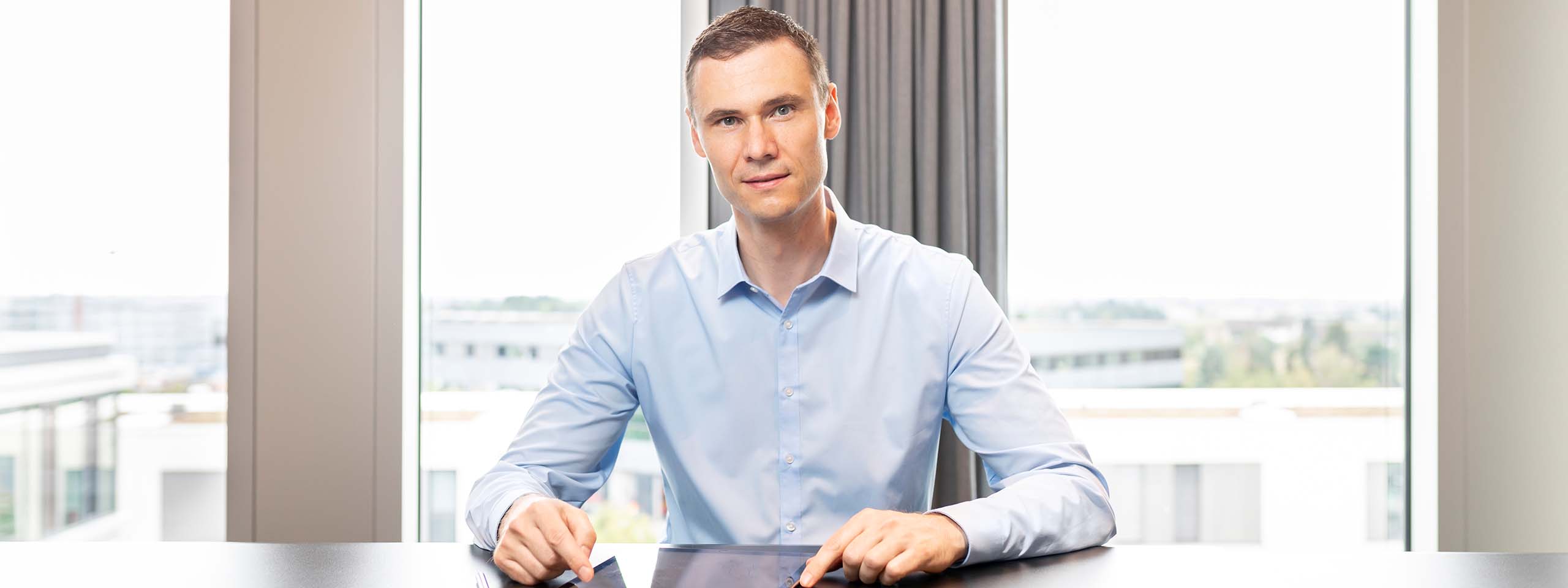 Dr. Bernd Kissling - Anwalt für Erbrecht und Vorsorge mit Blick in die Kamera im Hintergrund der Ausblick aus dem Büro