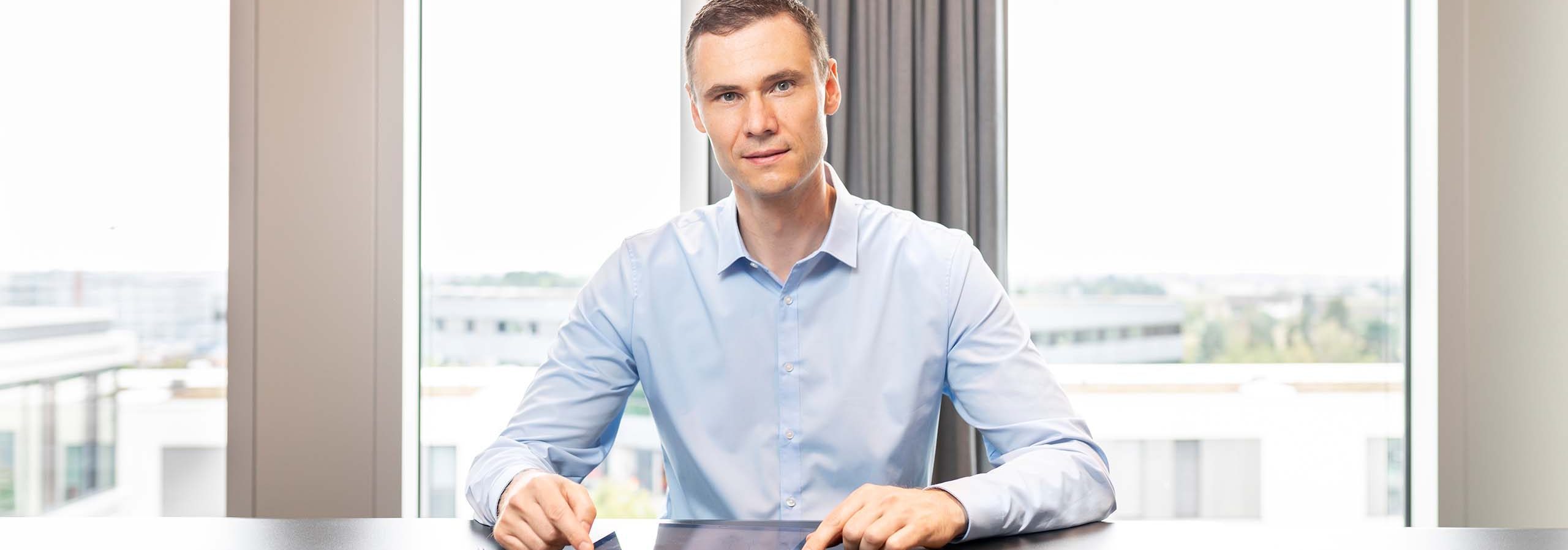 Dr. Bernd Kissling - Anwalt für Erbrecht und Vorsorge mit Blick in die Kamera im Hintergrund der Ausblick aus dem Büro
